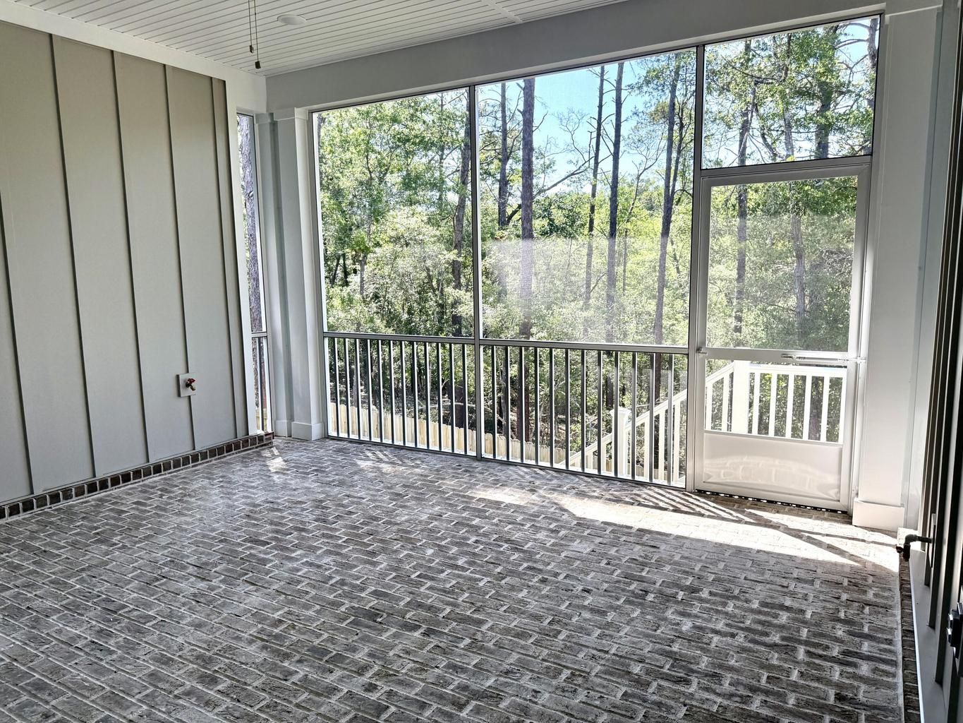Screened porch with brick floor overlooking the trees